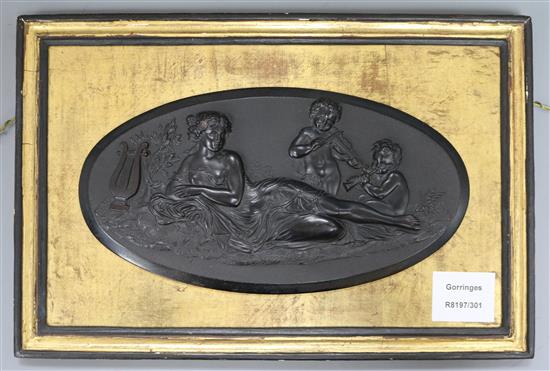 A Victorian pressed composition oval plaque, depicting a muse and two putti with musical instruments, on giltwood